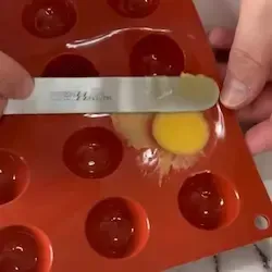 Spatola che rimuove l'eccesso di impasto dallo stampo