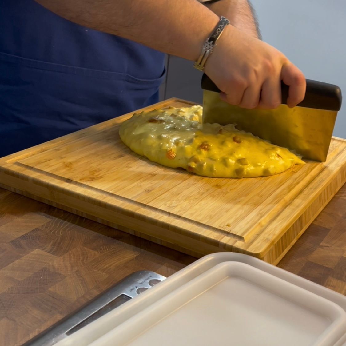 Una persona sta tagliando una pizza su un tagliere