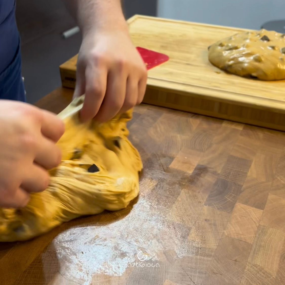 Una persona sta impastando la pasta su un tagliere di legno