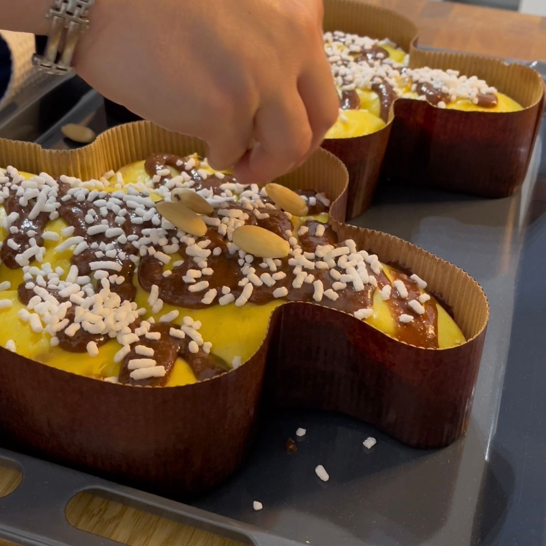 Una persona sta decorando una torta con cioccolato e granelli di zucchero
