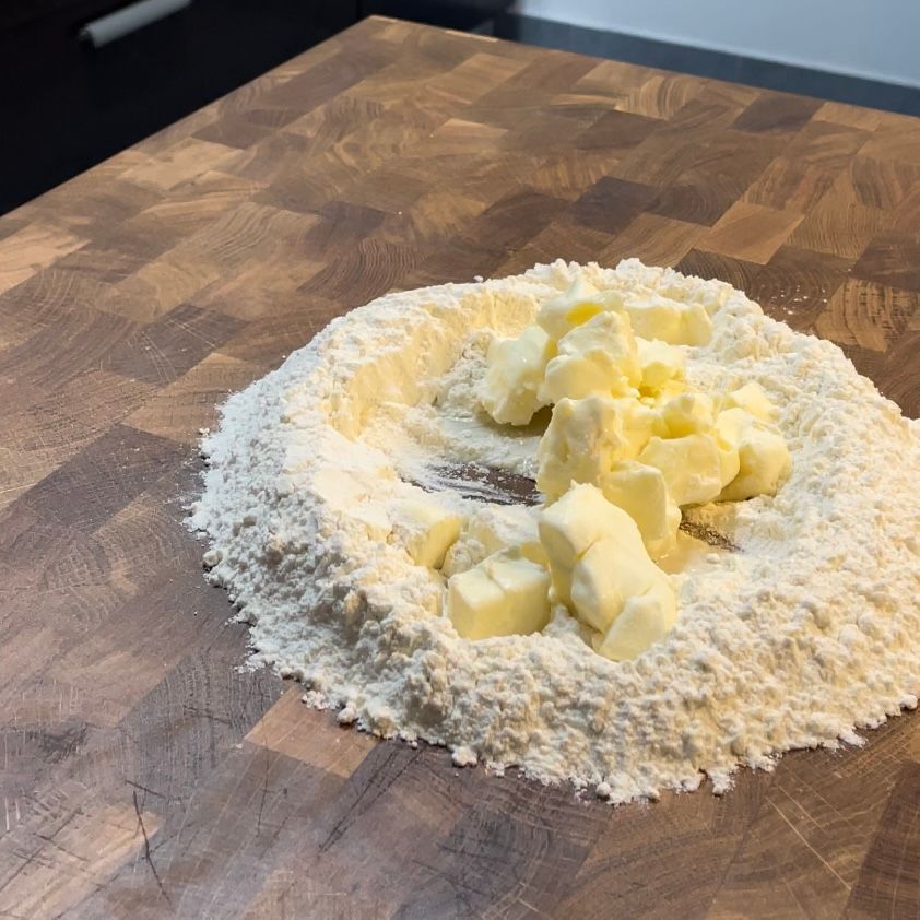 Un mucchio di farina e burro su un tagliere di legno