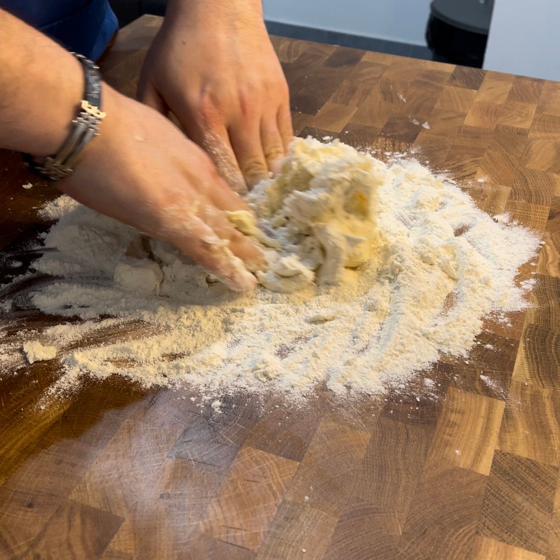 Una persona sta impastando la pasta su un tagliere di legno