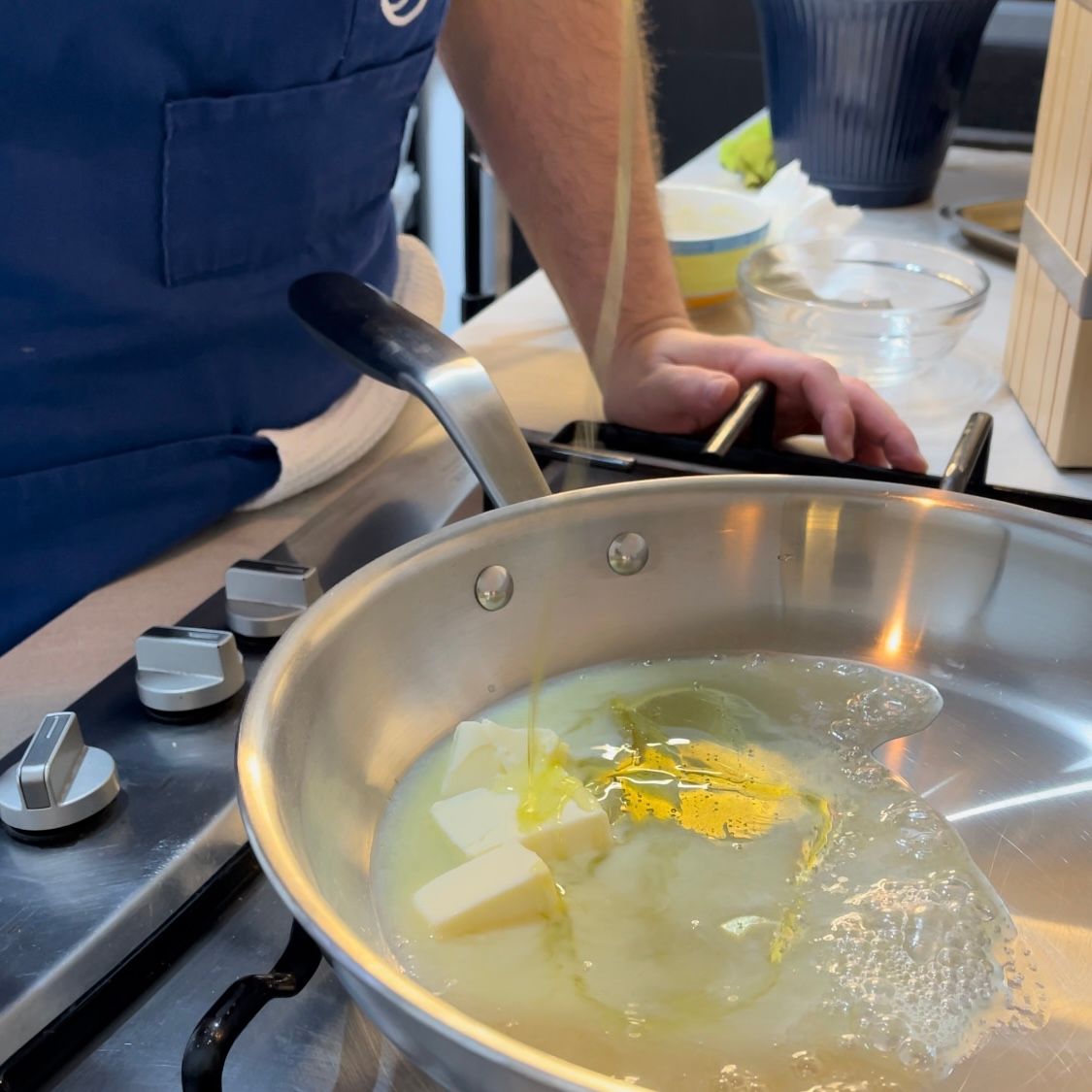 Una persona sta cucinando il burro in una padella su un fornello
