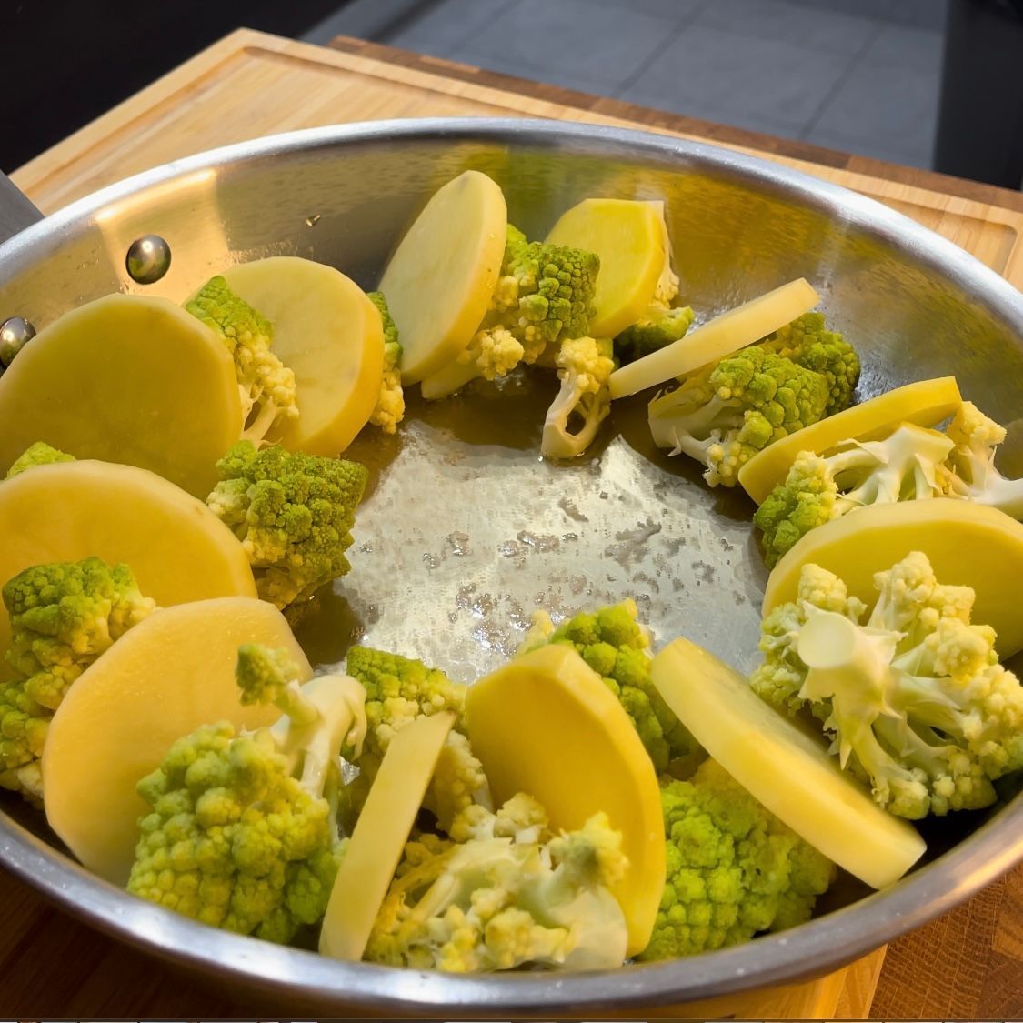 Una padella piena di patate a fette e broccoli