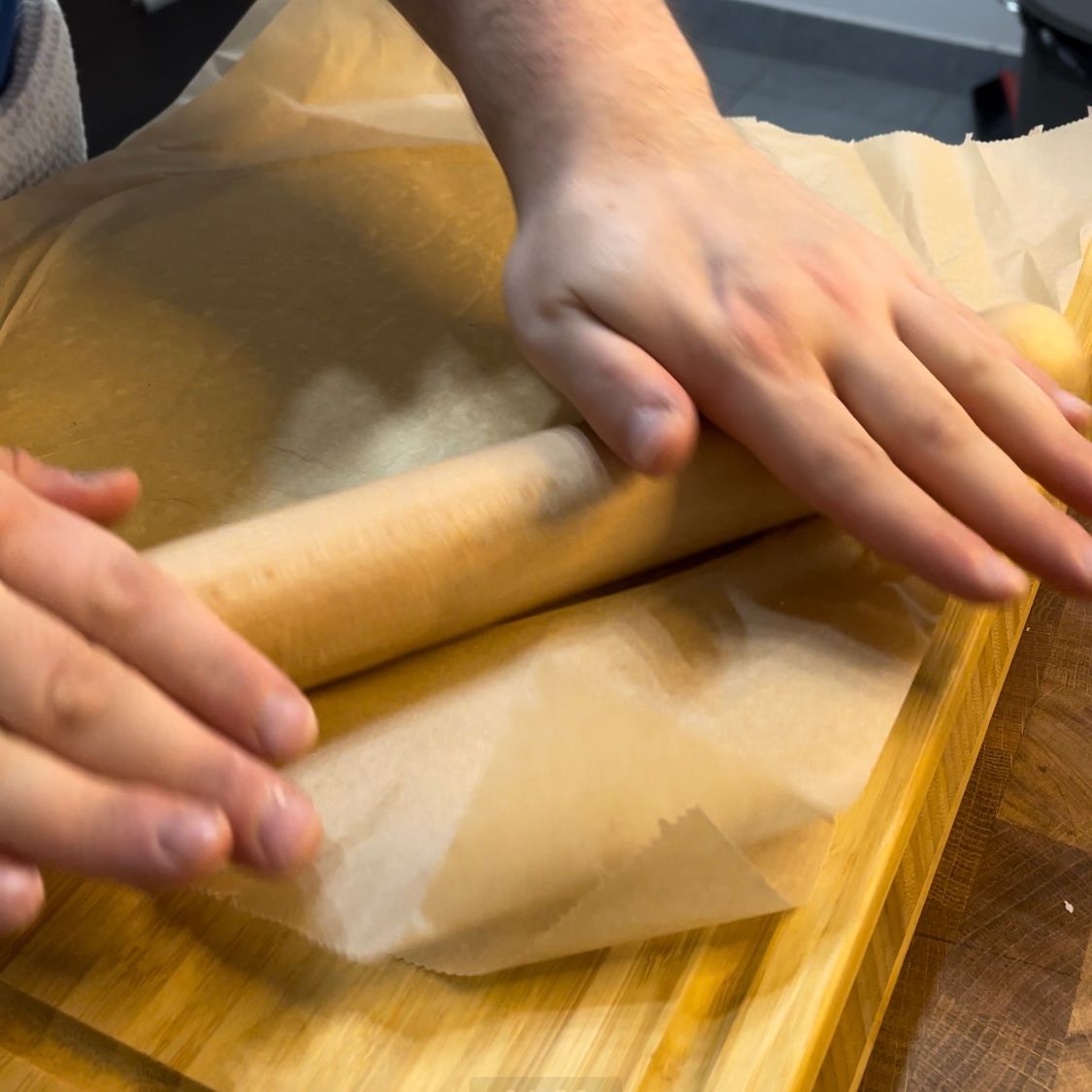 Una persona sta stendendo un pezzo di pasta con un mattarello