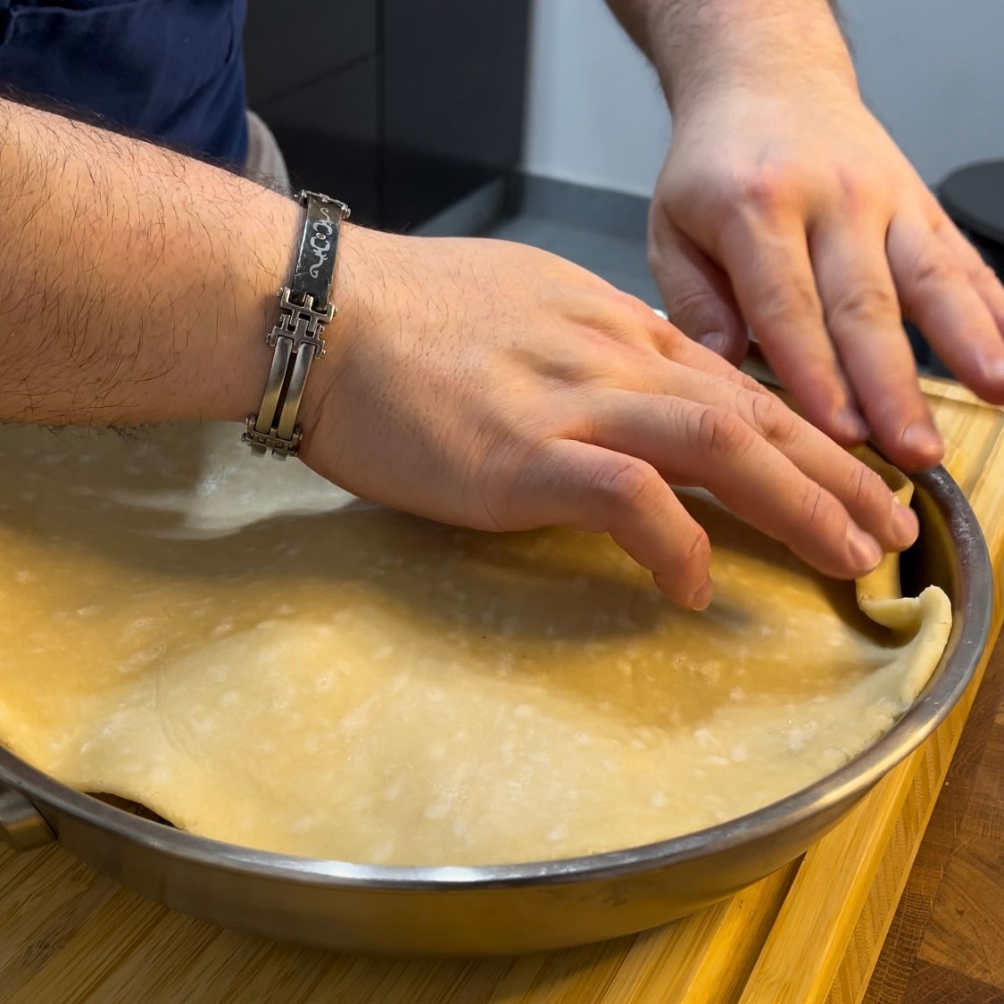 Una persona con un braccialetto al polso sta preparando una torta