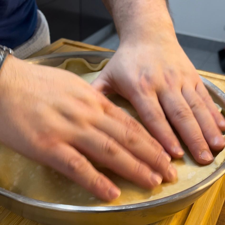 Una persona sta mettendo le mani su una crosta di torta
