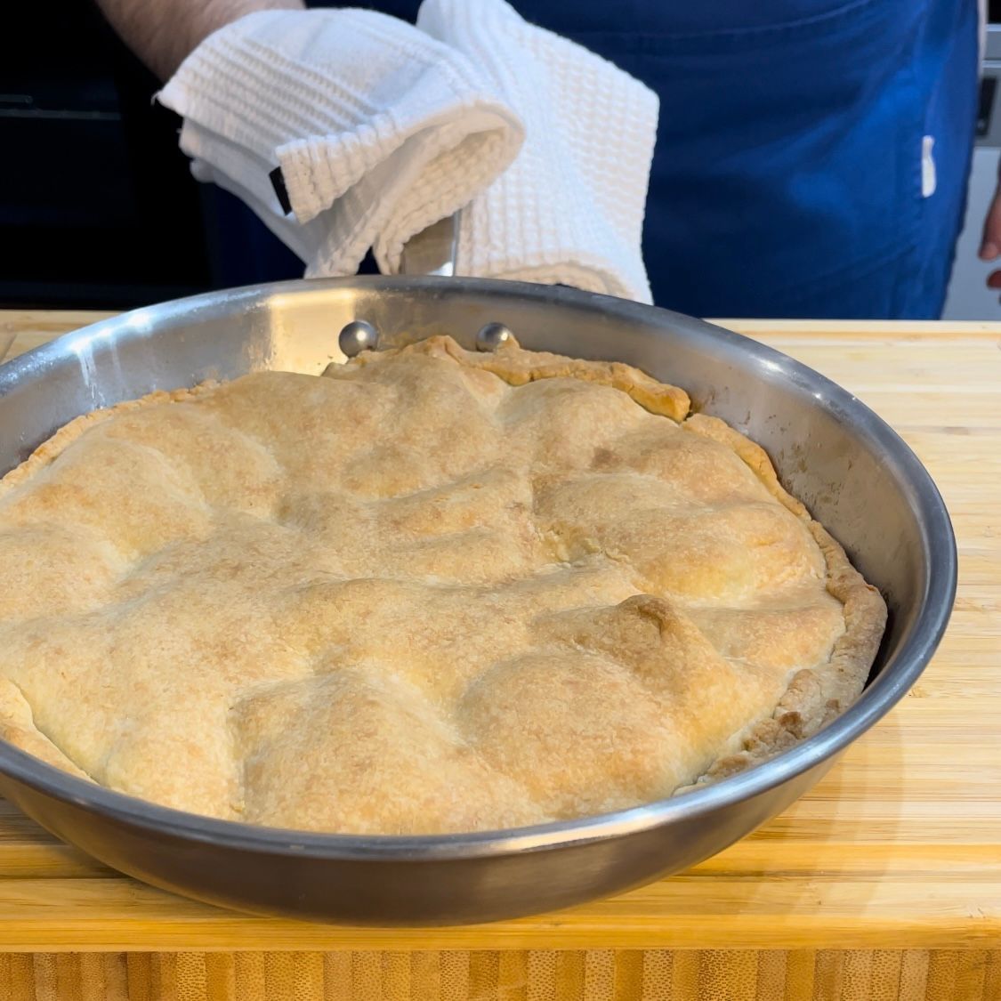 Una persona tiene un asciugamano sopra una pentola di cibo