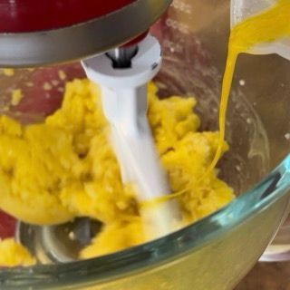 Uova sbattute versate a filo nell'impasto della pasta choux