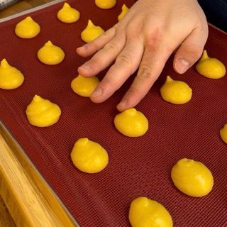 La mano di una persona sta cercando di prendere una palla gialla su un tappetino rosso