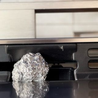 Un pezzo di foglio di alluminio è appoggiato su una superficie metallica