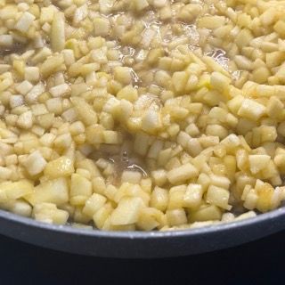 Primo piano di una padella piena di mele tritate.