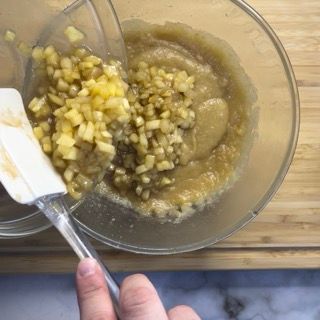 Una persona tiene una spatola sopra una ciotola di cibo.