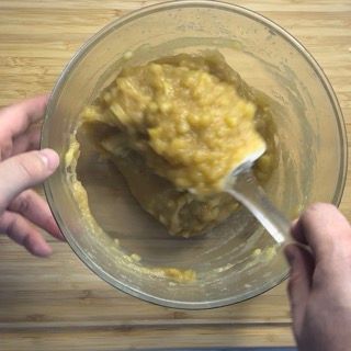 Una persona sta mescolando qualcosa in una ciotola con una forchetta