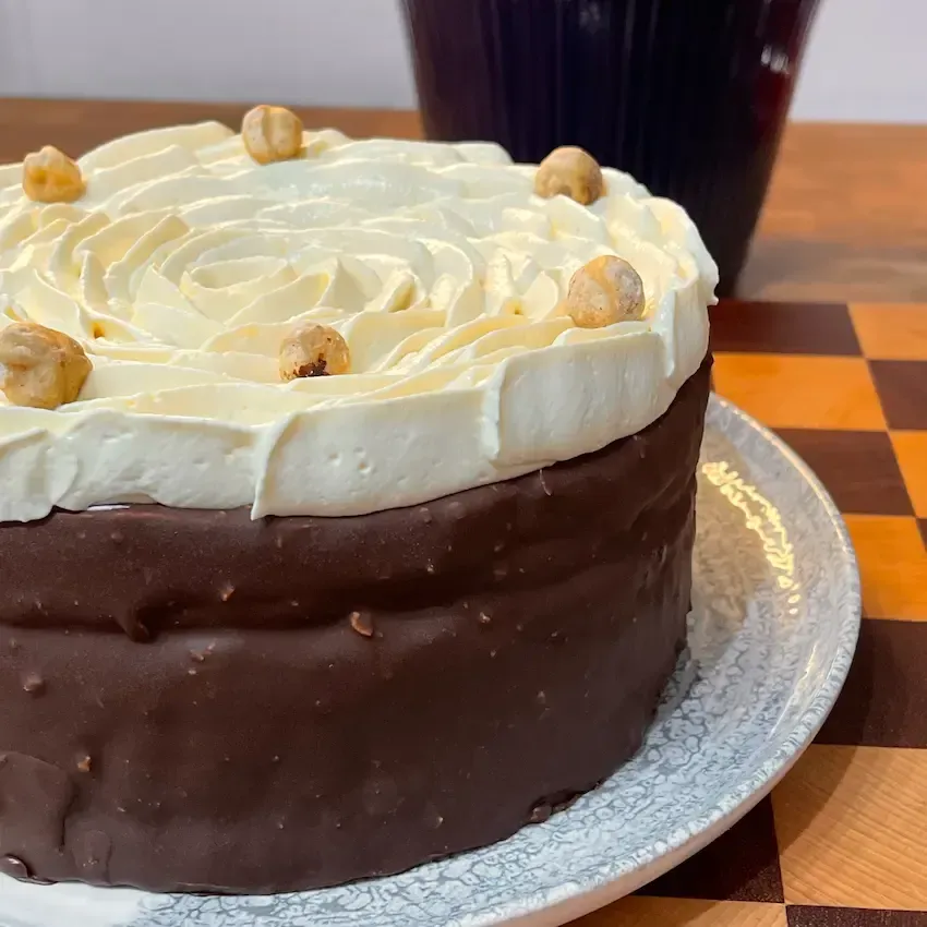 Torta Tiramisù moderna alla nocciola con glassa rocher al cioccolato e decorazione a fiore