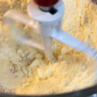 Un mixer mescola un composto di farina e burro in una ciotola.