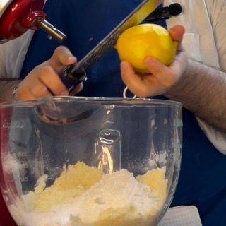 Zucchero a velo, vaniglia e scorza di limone aggiunti all'impasto sabbioso.