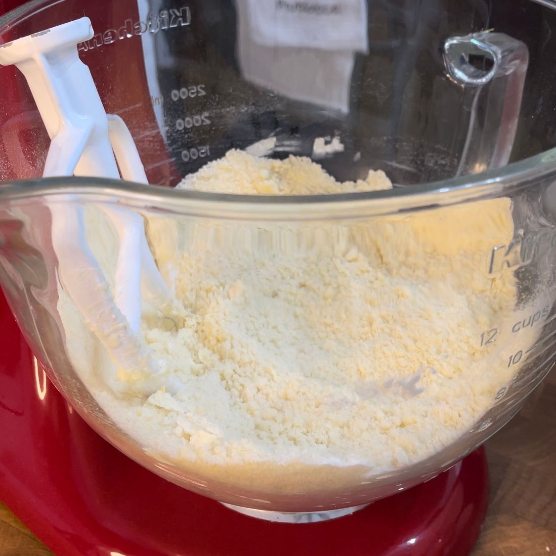 Un misurino di vetro pieno di polvere bianca è su un mixer rosso