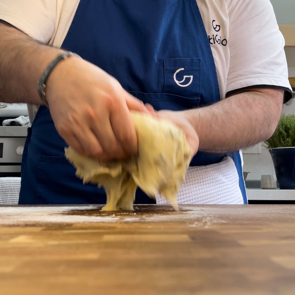 Un uomo che indossa un grembiule blu con la lettera g sopra