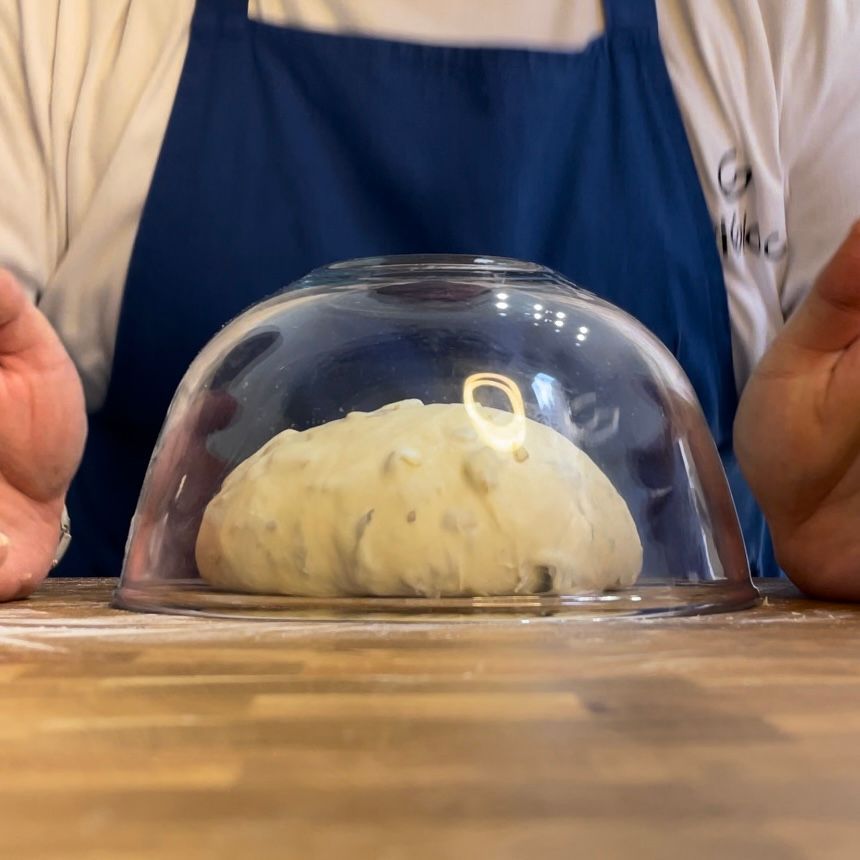 Una persona tiene una cupola di vetro sopra una palla di pasta