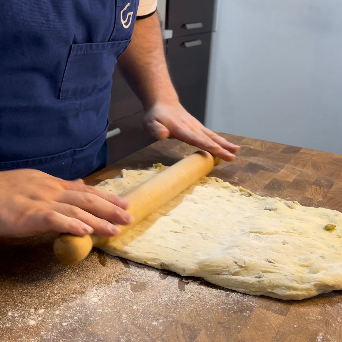 Una persona sta stendendo la pasta con un mattarello
