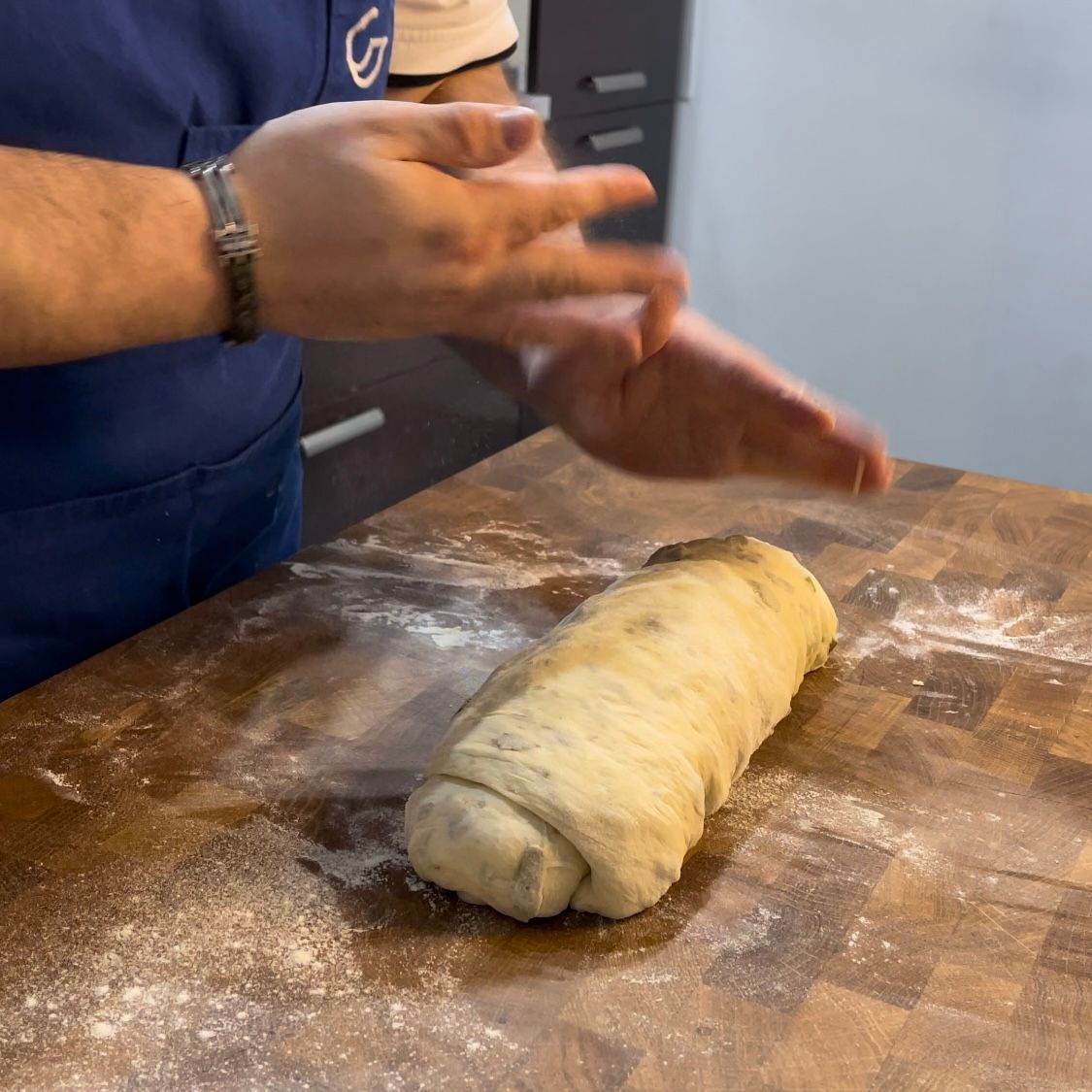 Una persona sta impastando la pasta su un tagliere di legno
