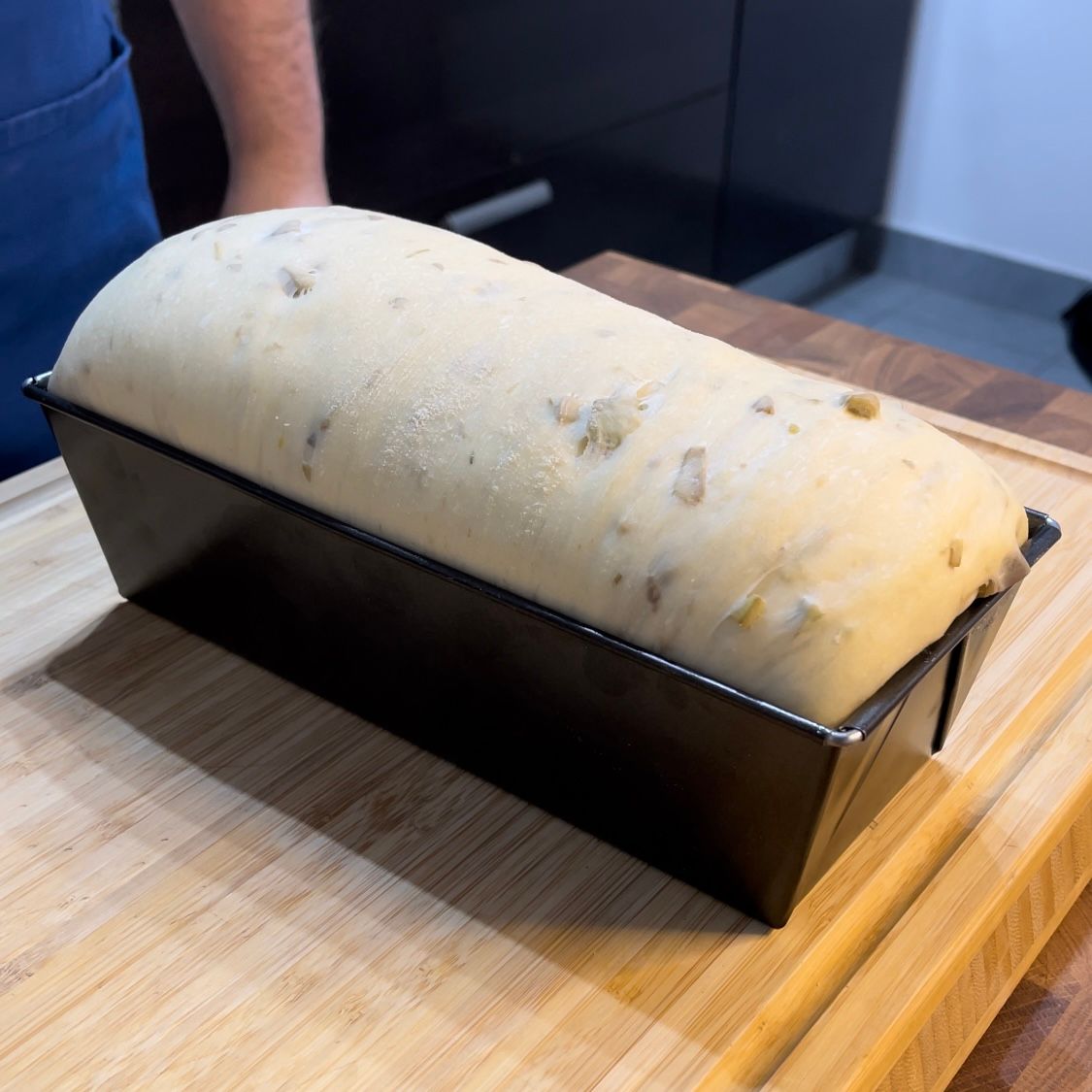 Una pagnotta di pane è appoggiata su un tagliere di legno.