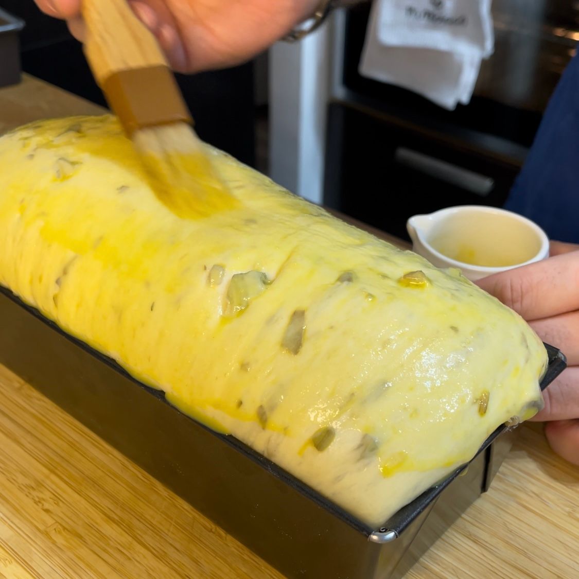 Una persona sta spazzolando una pagnotta di pane con una spazzola