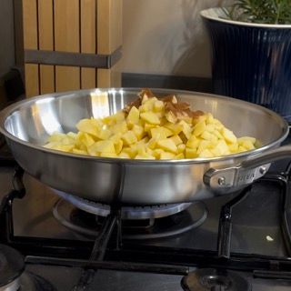 Una padella piena di patate sta cuocendo su un fornello