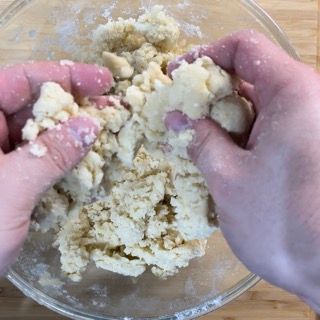 Una persona sta mescolando qualcosa in una ciotola con le mani