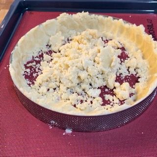 Una crosta di torta è appoggiata su un tappetino rosso su un vassoio