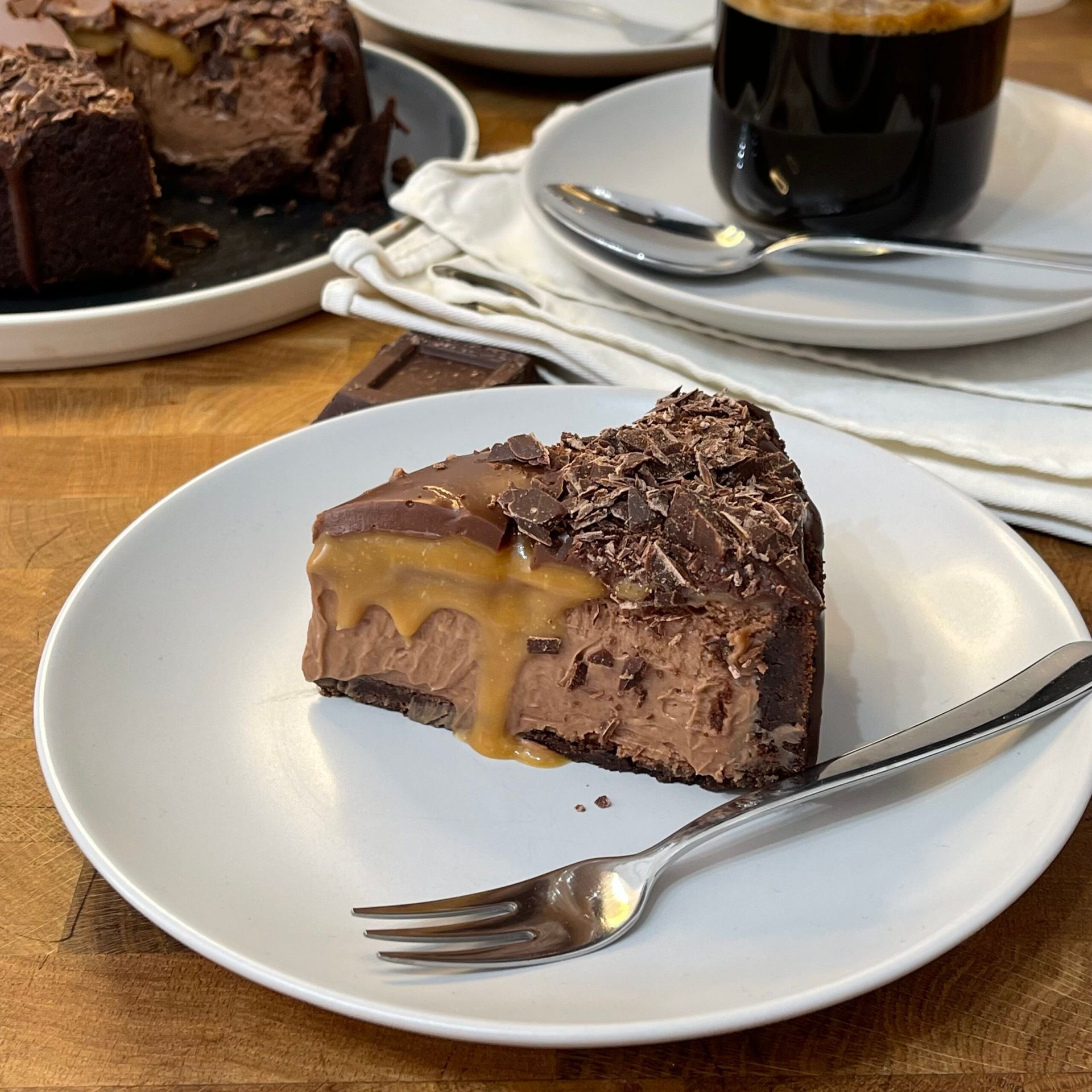 Una fetta di cheesecake al cioccolato su un piatto bianco con una forchetta