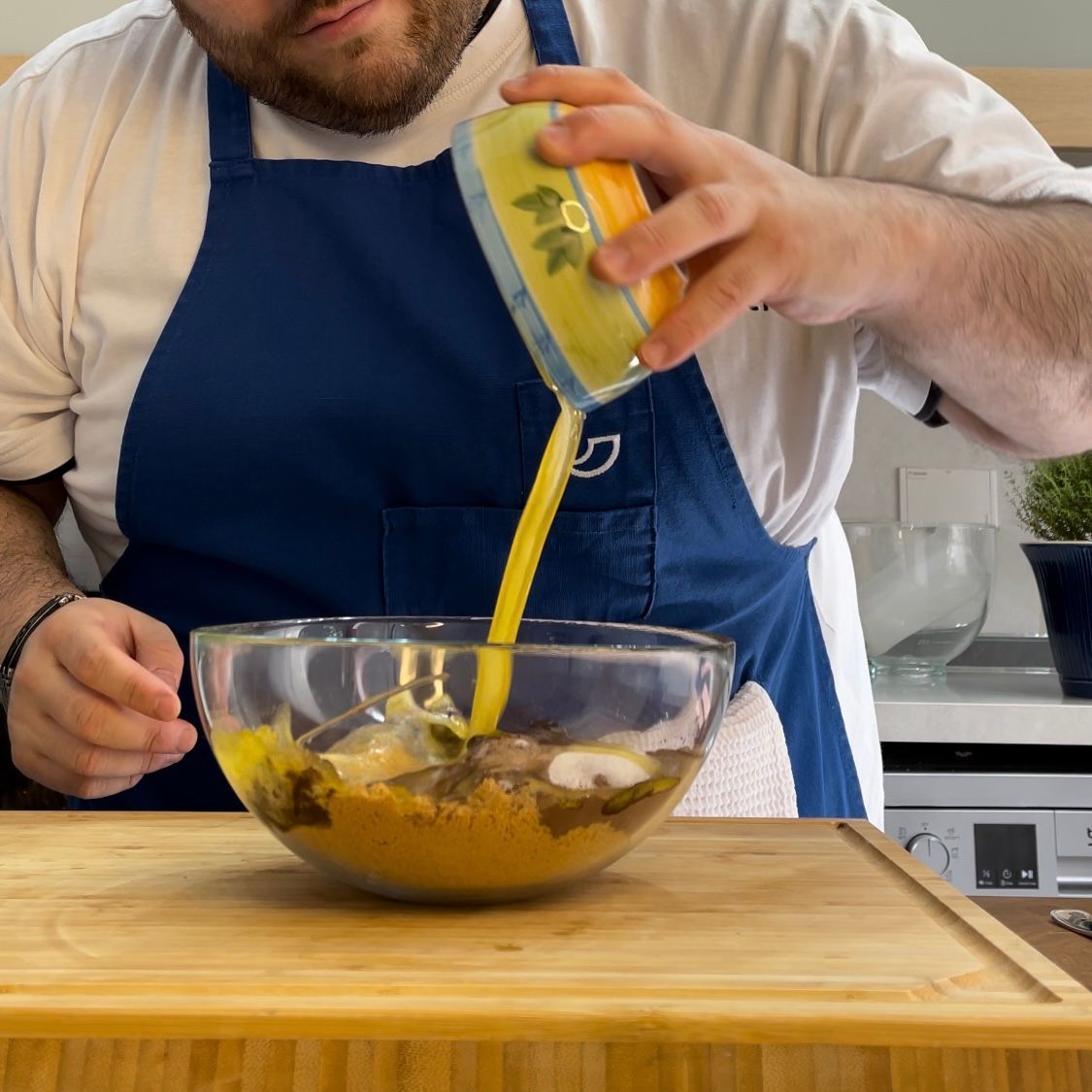 Un uomo con un grembiule sta versando qualcosa in una ciotola