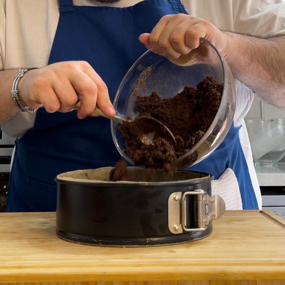 Una persona versa la pastella in una padella con un cucchiaio