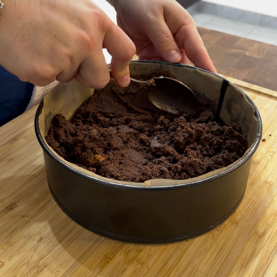 Una persona sta mescolando un impasto per torta con un cucchiaio