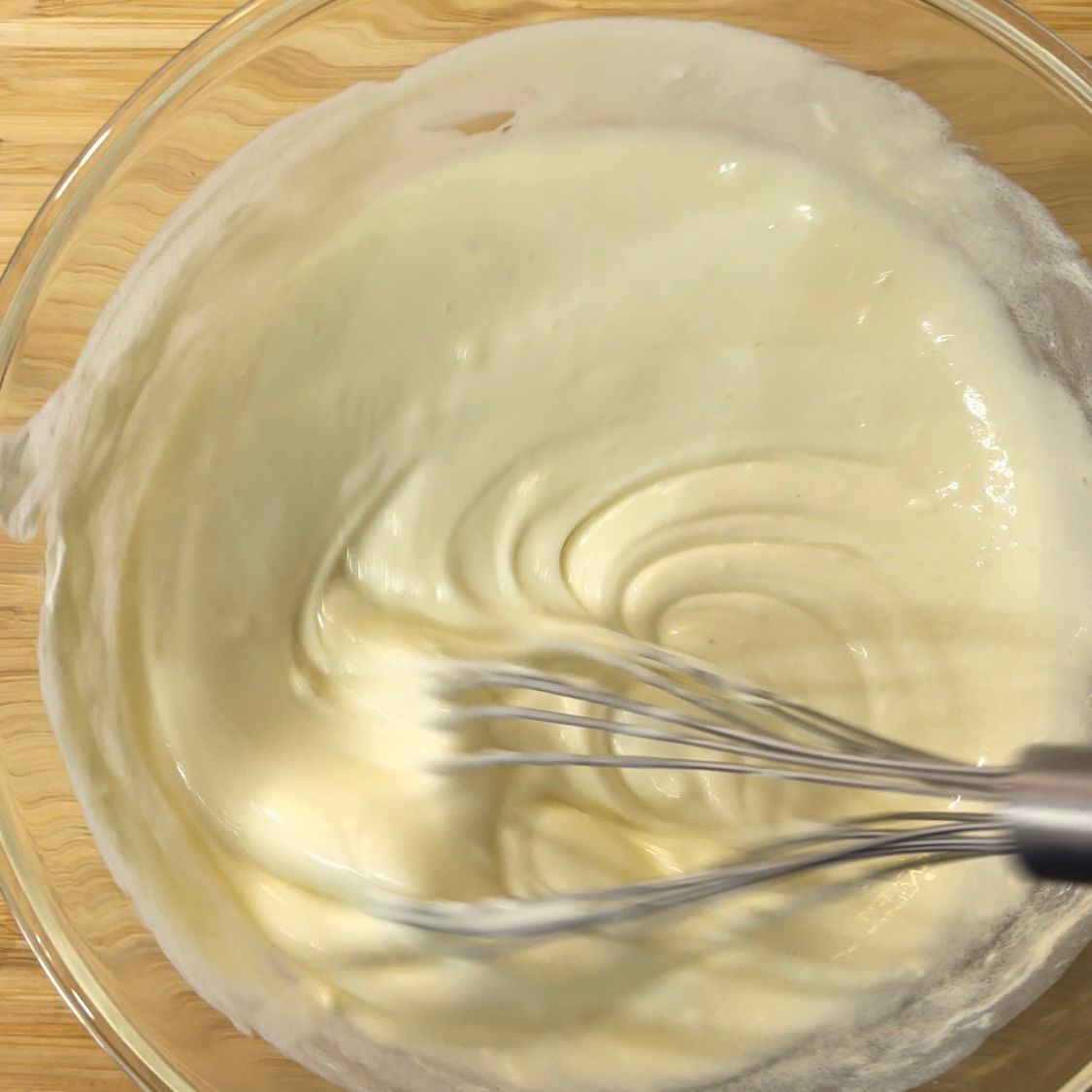 Una ciotola di panna montata con una frusta dentro.