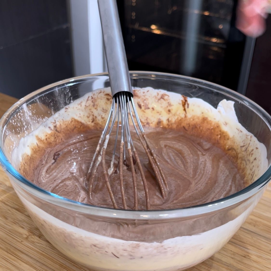 Una ciotola di salsa al cioccolato con una frusta dentro