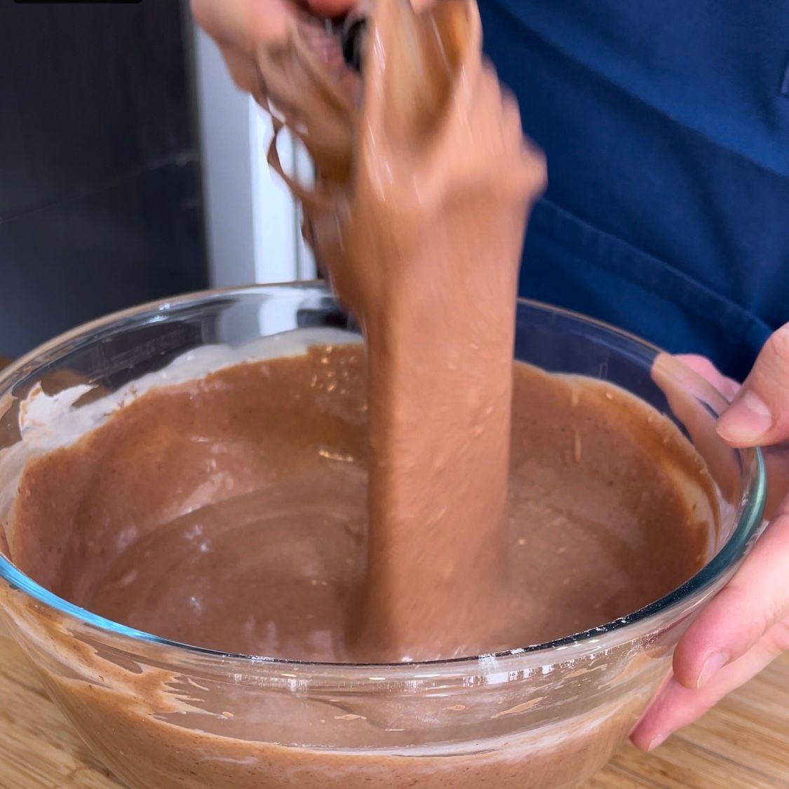 Una persona sta versando del cioccolato in una ciotola di vetro