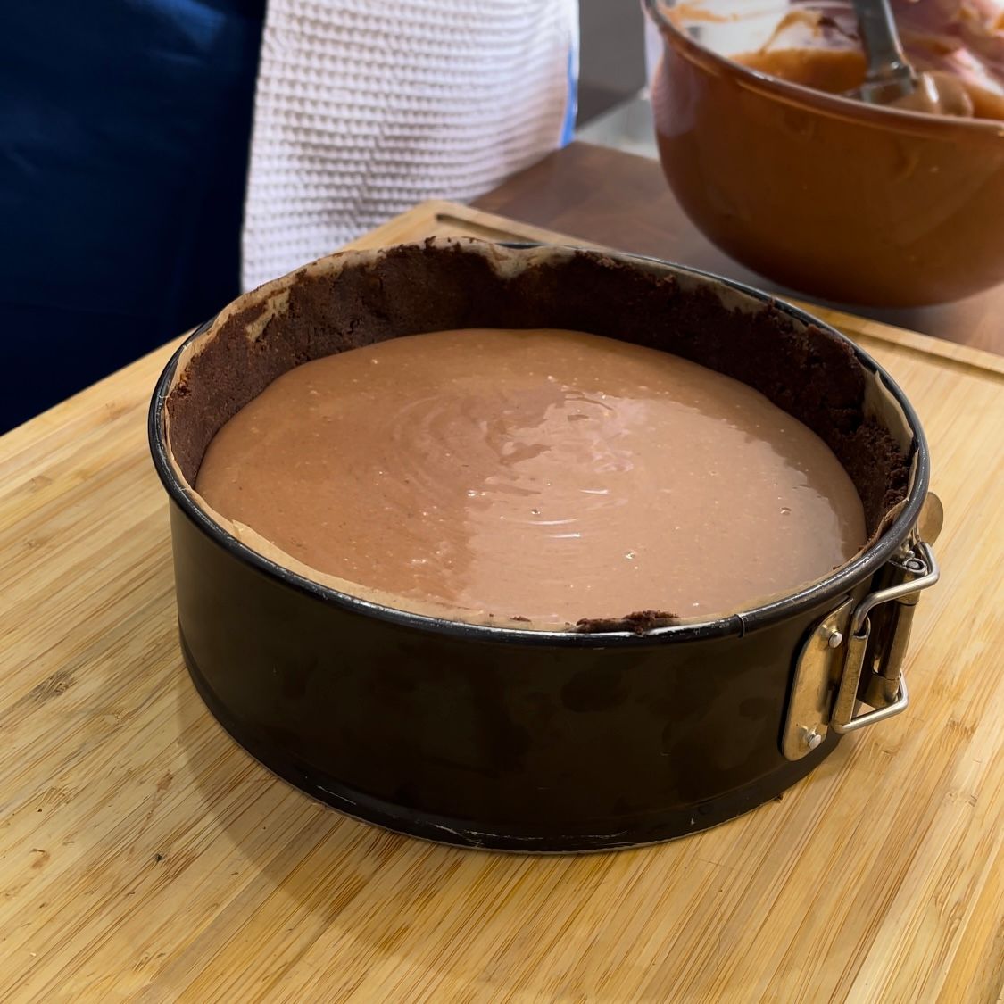 Una torta al cioccolato è appoggiata su un tagliere di legno