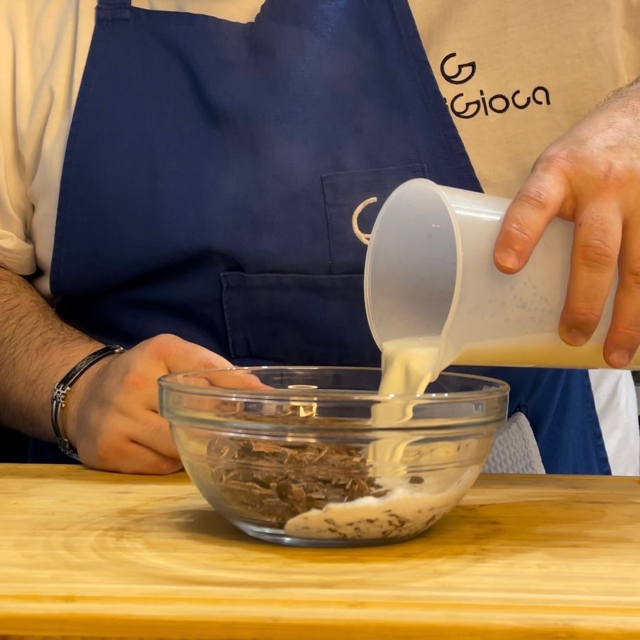 Una persona che versa il latte in una ciotola con la parola gioca sul grembiule