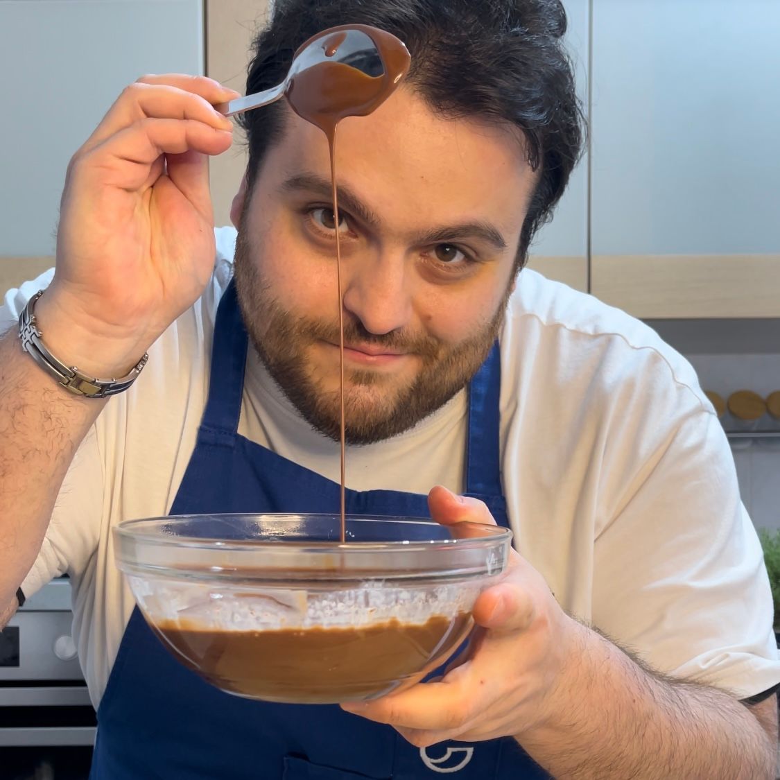 Un uomo versa il cioccolato in una ciotola con un cucchiaio