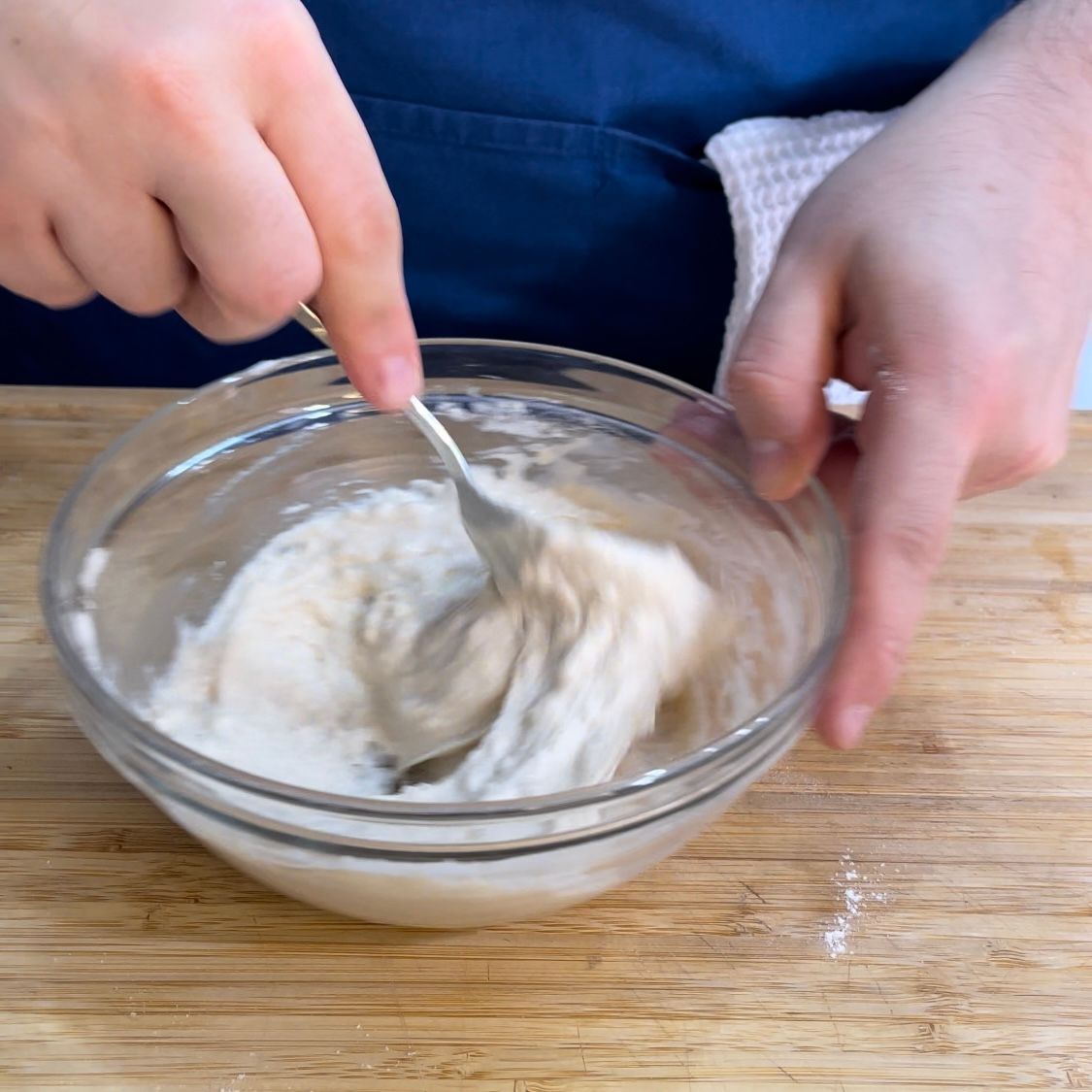 Una persona sta mescolando qualcosa in una ciotola con un cucchiaio