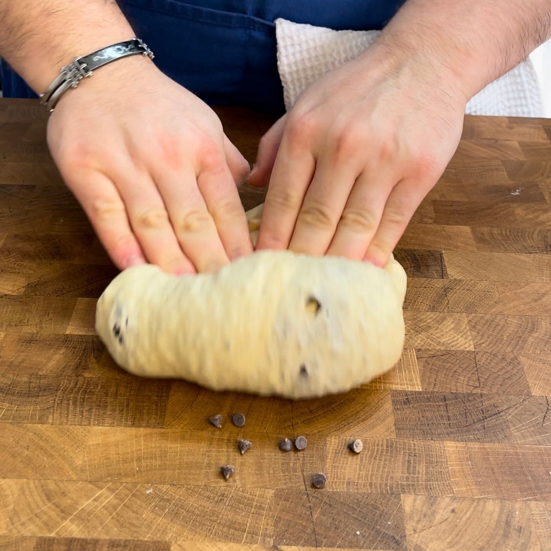 Una persona sta impastando una pagnotta di pasta su un tagliere di legno