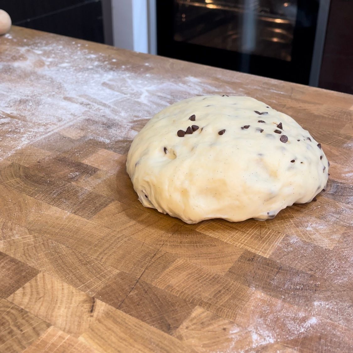 Una palla di pasta è appoggiata su un tagliere di legno