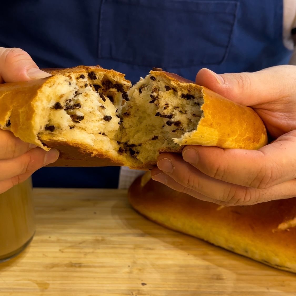 Una persona tiene in mano un pezzo di pane con gocce di cioccolato.