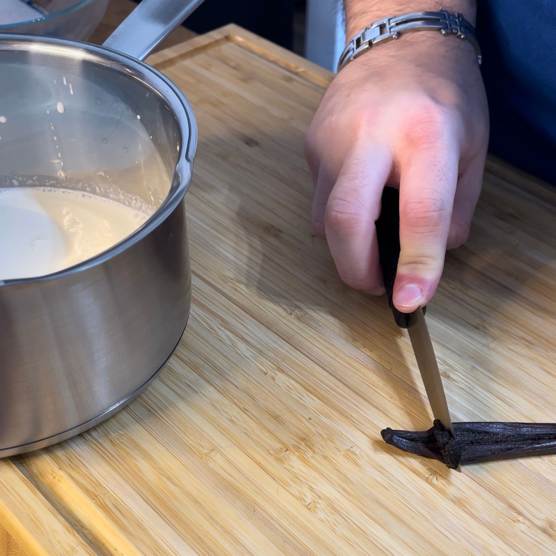 Una persona sta tagliando una bacca di vaniglia su un tagliere