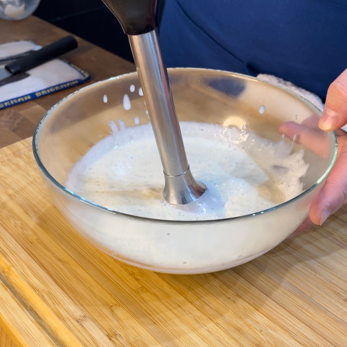 Una persona sta mescolando qualcosa in una ciotola con un frullatore