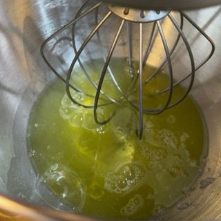 Un primo piano di una frusta in una ciotola di liquido