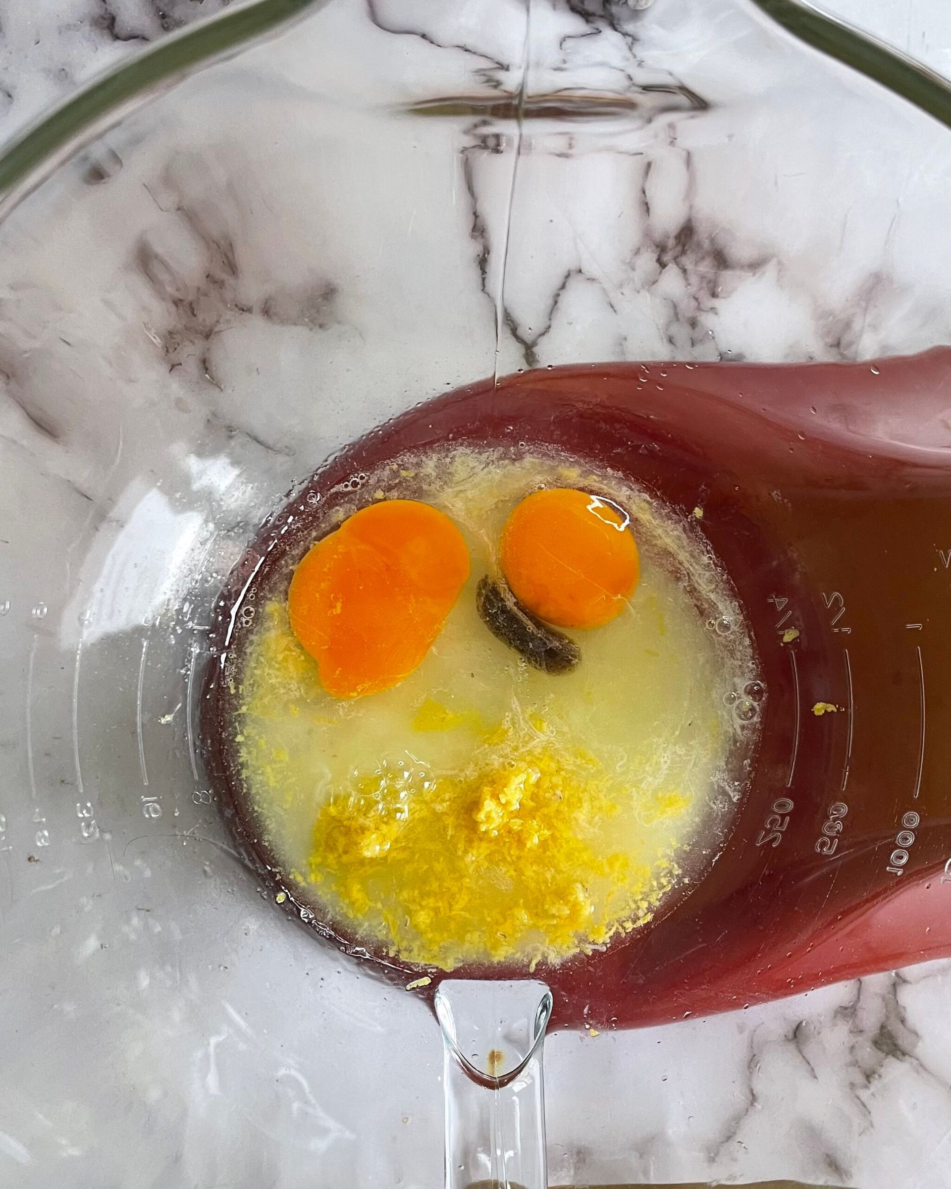 Primo piano di due uova in una ciotola con una spatola.