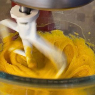 Un mixer sta mescolando un liquido giallo in una ciotola di vetro